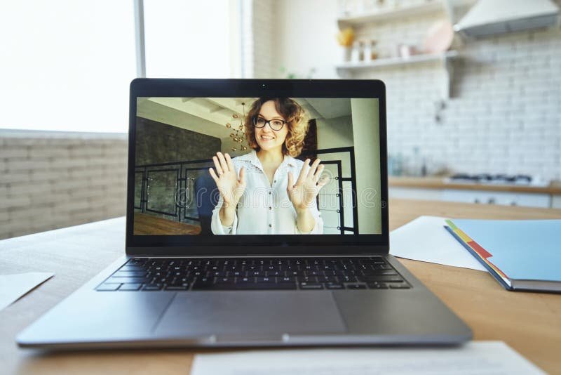 Friendly teacher smiling and waving goodbye in a digital classroom